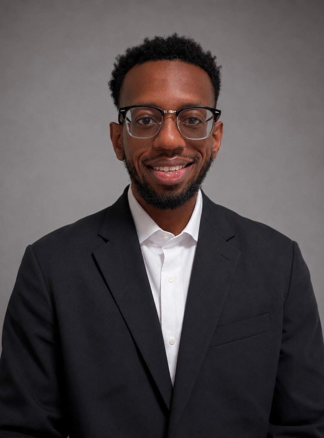 Smiling person in suit wearing glasses