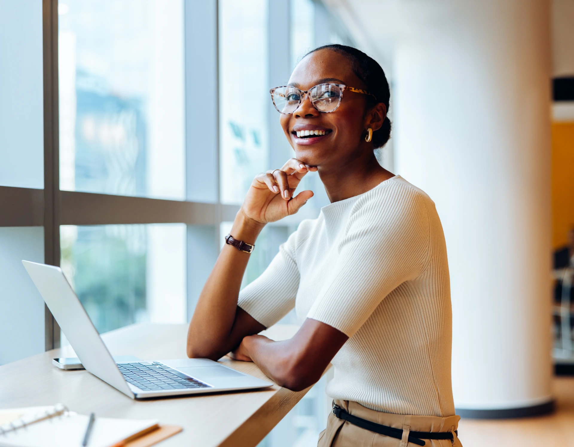 Woman smiling while working on laptop